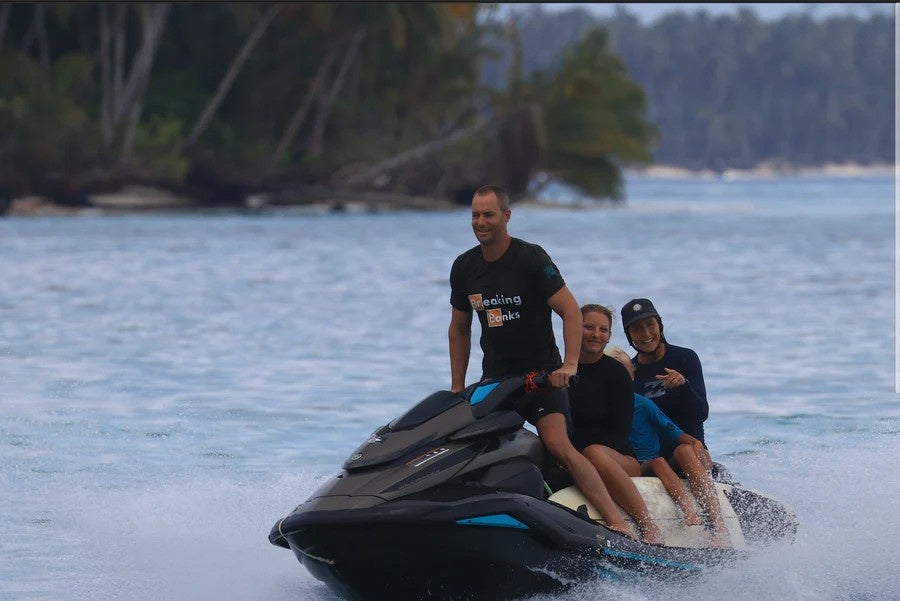 heidi and toby riding a jetski with crypto merchandise tshirts